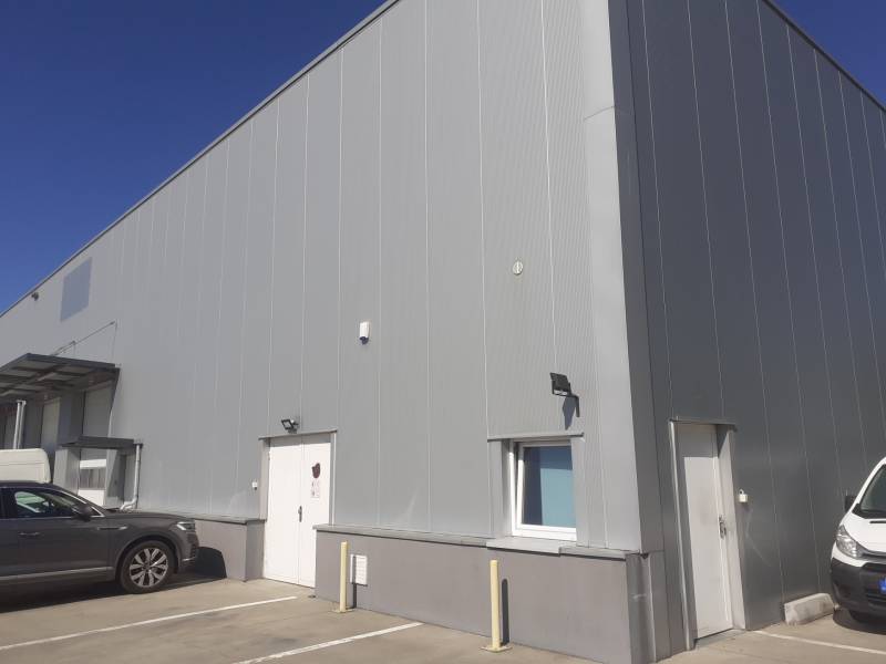 Lagerhäuser und Hallen in der Technická-Straße in Bratislava-Ružinov, mit geparkten Autos vor dem Eingang.