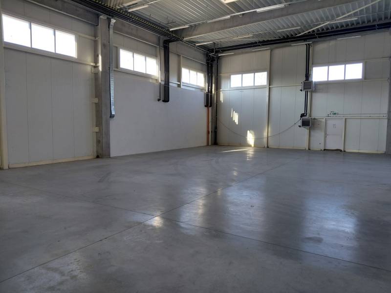 Pohľad do prázdnej haly so svetlými stenami v skladoch a halách.