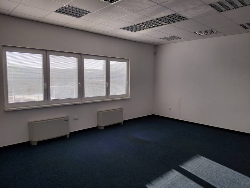 Innenräume von Lagern und Hallen mit blauem Teppich, großen Fenstern und weißen Wänden.