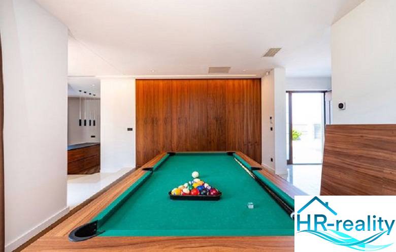 Ein Billardtisch im Inneren der Villa mit einem Boden in Holzoptik.