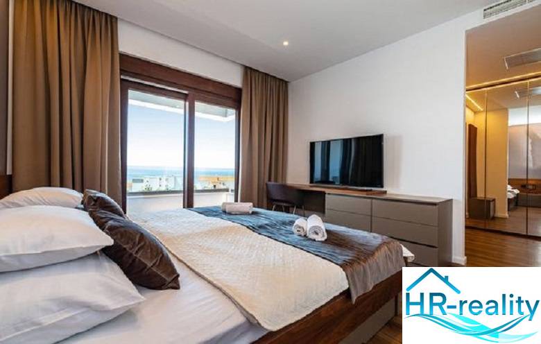 Innenraum der Villa mit Bett, Fernseher und Meerblick.