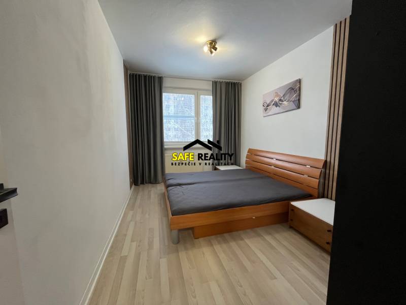 Schlafzimmer mit hellen Wänden, Doppelbett und Boden in Holzoptik in einer 3-Zimmer-Wohnung.