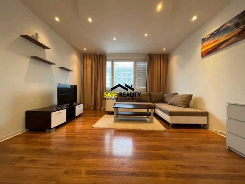 Wohnzimmer mit Holzboden, Sofa und Fernseher in einer 3-Zimmer-Wohnung.