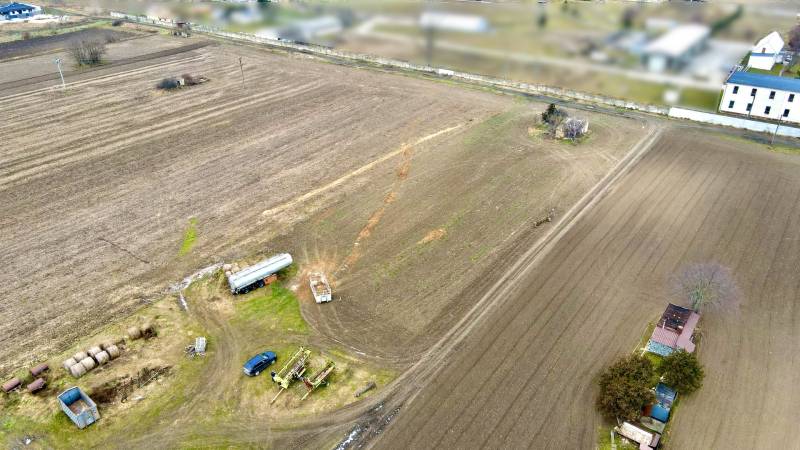 Blick auf Ackerland mit landwirtschaftlichen Maschinen in der Kasárenská-Straße in Sereď, Grundstücke - Wohnen.