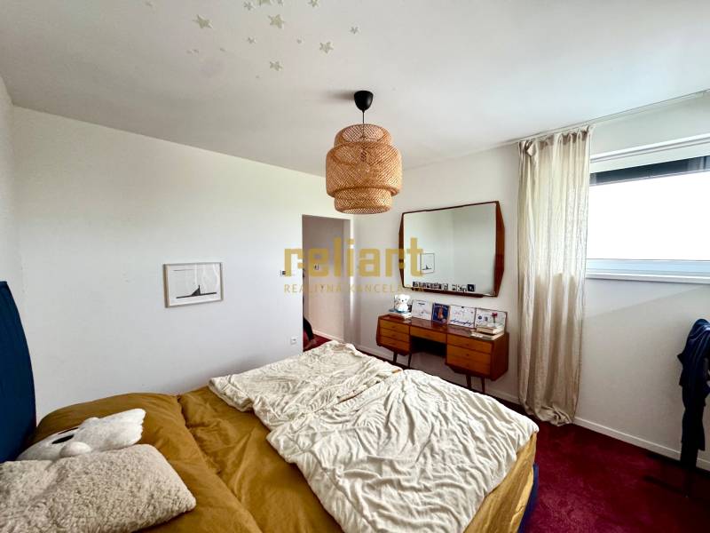 Ein Schlafzimmer in einem Einfamilienhaus mit einem Bett, einem Spiegel und einem roten Teppich auf dem Boden.