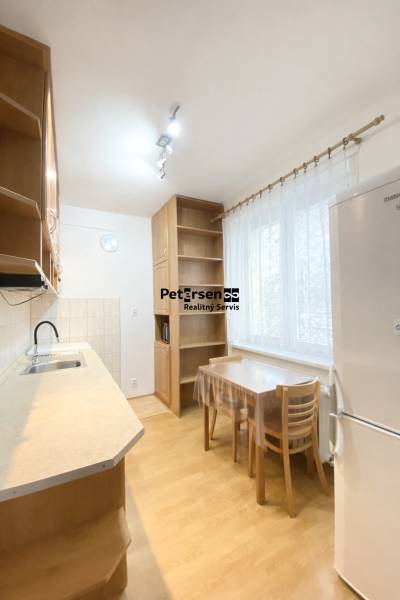 Küche in einer 2-Zimmer-Wohnung mit Holzboden, einfache Möbel und Geräte.