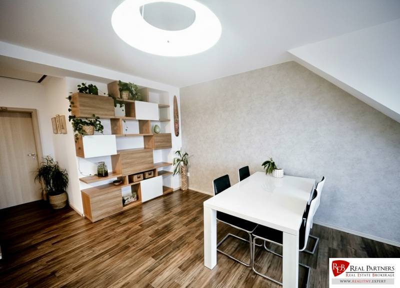 Esstisch, Stühle und Regale mit Dekorationselementen in einer 3-Zimmer-Wohnung mit Holzdekorboden.