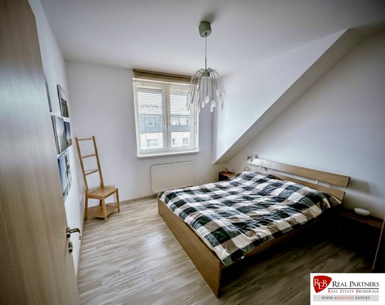 Schlafzimmer in einer 3-Zimmer-Wohnung mit Bett und Holzboden.