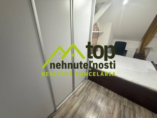 Schlafzimmer in einer Einzimmerwohnung mit Holzboden und Einbauschrank.