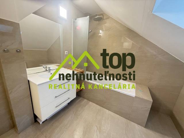 Badezimmer in einer Einzimmerwohnung mit Duschkabine und Waschbecken.