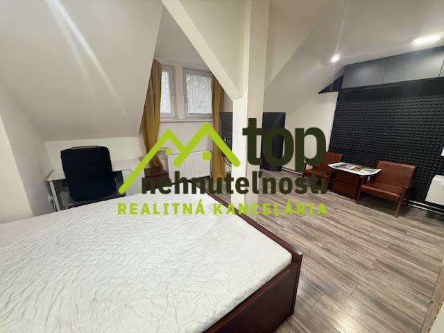 Schlafzimmer in einer Einzimmerwohnung mit Holzboden und Schreibtisch.