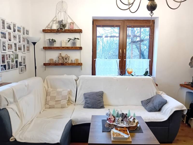 Wohnzimmer in einem Einfamilienhaus mit Sofa, Fotogalerie, Regalen und Dekorationen.