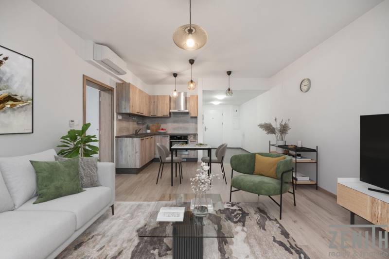 Wohnzimmer mit Küchenzeile in einer 2-Zimmer-Wohnung mit Holzboden und bequemen Sitzgelegenheiten.