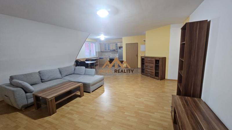 Wohnzimmer mit Sofa, Küche und Holzboden in einer 3-Zimmer-Wohnung.