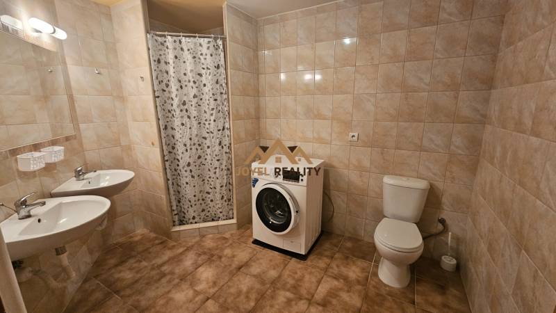 Badezimmer in einer 3-Zimmer-Wohnung mit Dusche, Doppelwaschbecken, Toilette und Waschmaschine.