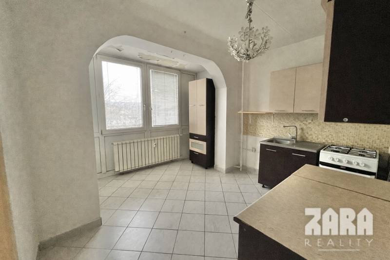 Küche mit Fliesen und Fenster, 3-Zimmer-Wohnung mit Herd und Spüle.