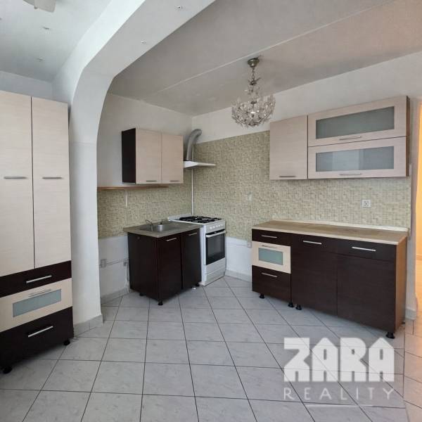 Küche in einer 3-Zimmer-Wohnung mit Fliesenboden und Küchenzeile.