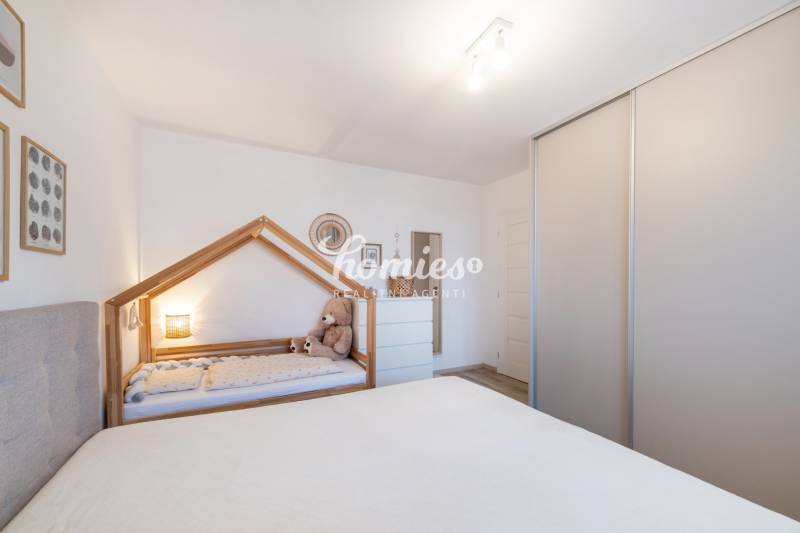 Kinderzimmer in einer Zweizimmerwohnung mit Kinderbett und Schrank.