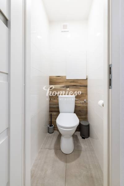 Toilette in einer 2-Zimmer-Wohnung mit Holzboden.