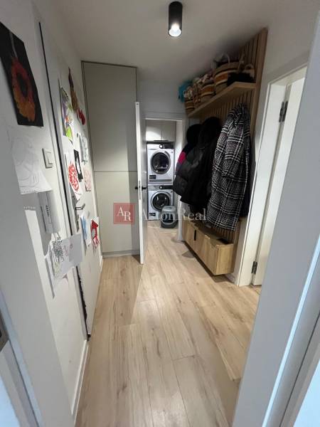 Ein schmaler Flur mit Schränken und einem Holzboden in einer 4-Zimmer-Wohnung.