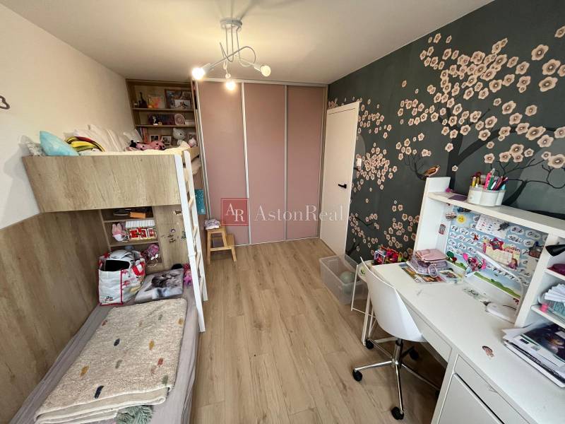 Kinderzimmer mit Etagenbett, Schreibtisch und Boden mit Holzdekor in einer 4-Zimmer-Wohnung.