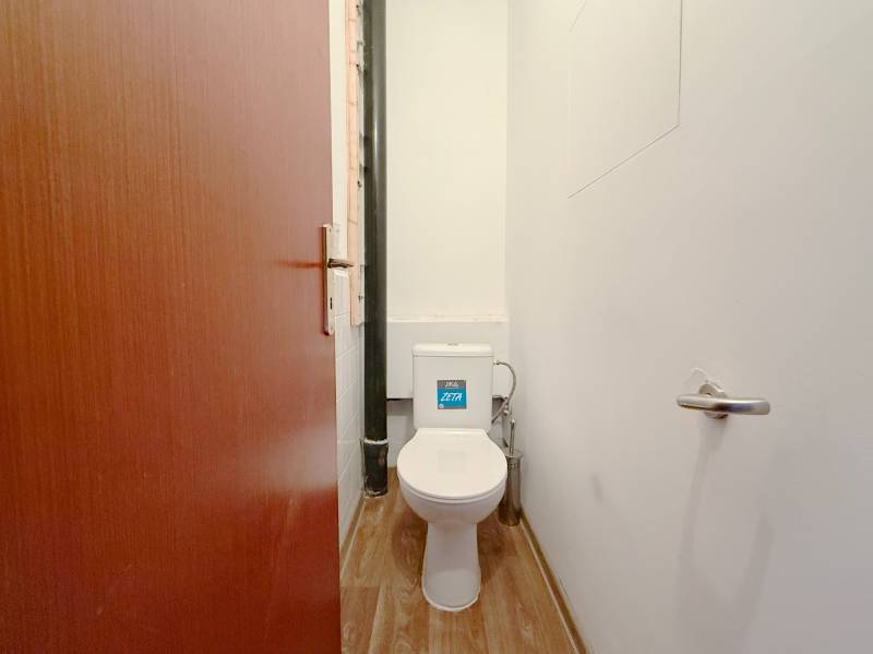 Toilette mit Holzboden-Dekor in einer 4-Zimmer-Wohnung.