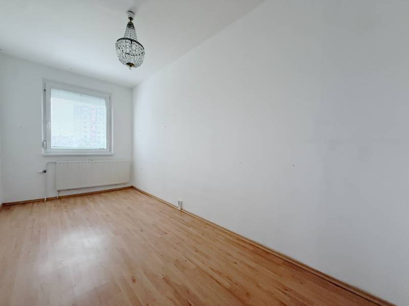 Zimmer in einer 4-Zimmer-Wohnung mit Kronleuchter und Boden in Holzoptik.