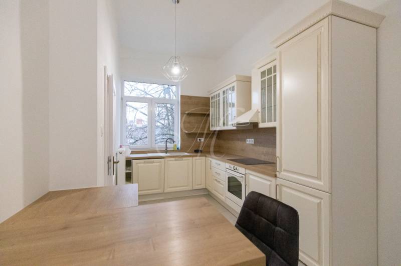 Küche in einer 3-Zimmer-Wohnung mit einem Boden in Holzoptik und klassischen Küchenschränken.