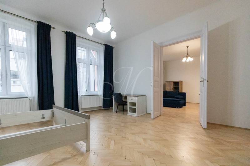 Innenraum einer 3-Zimmer-Wohnung mit Holzboden, Möbeln und Kronleuchter.