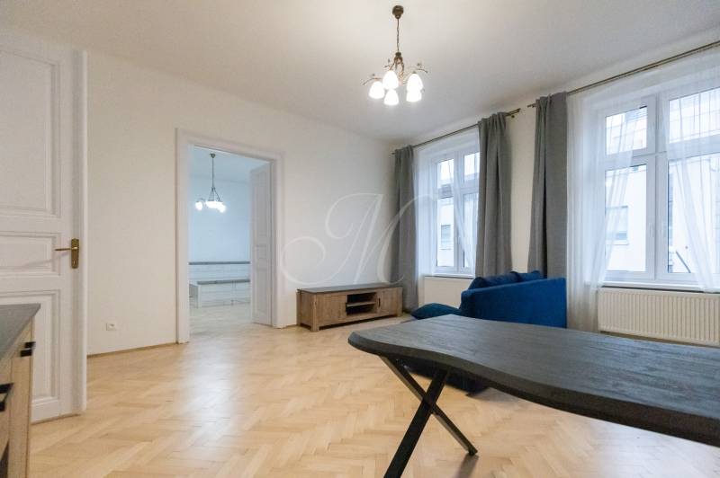 Wohnzimmer in einer 3-Zimmer-Wohnung mit Holzboden und blauer Couch.