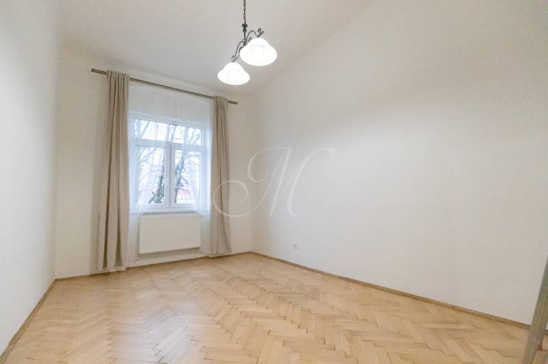 Ein Zimmer in einer 3-Zimmer-Wohnung mit einem Boden in Holzoptik und einem großen Fenster.