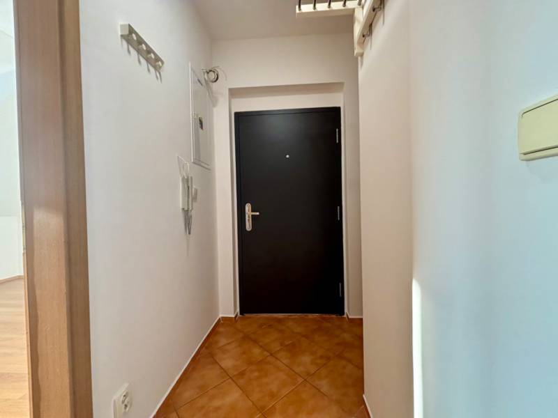 Eingangsflur mit dunklen Türen in einer 2-Zimmer-Wohnung, weiße Wände und Fliesen.