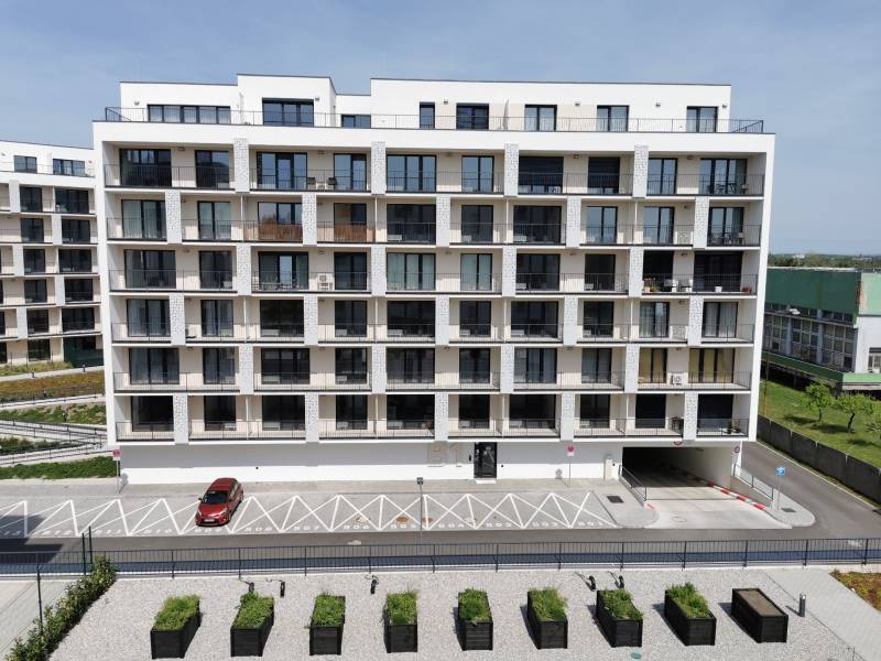 Ein modernes Wohngebäude mit Parkplätzen und Grünflächen in der Eduarda-Wenzla-Straße in Bratislava-Rača.