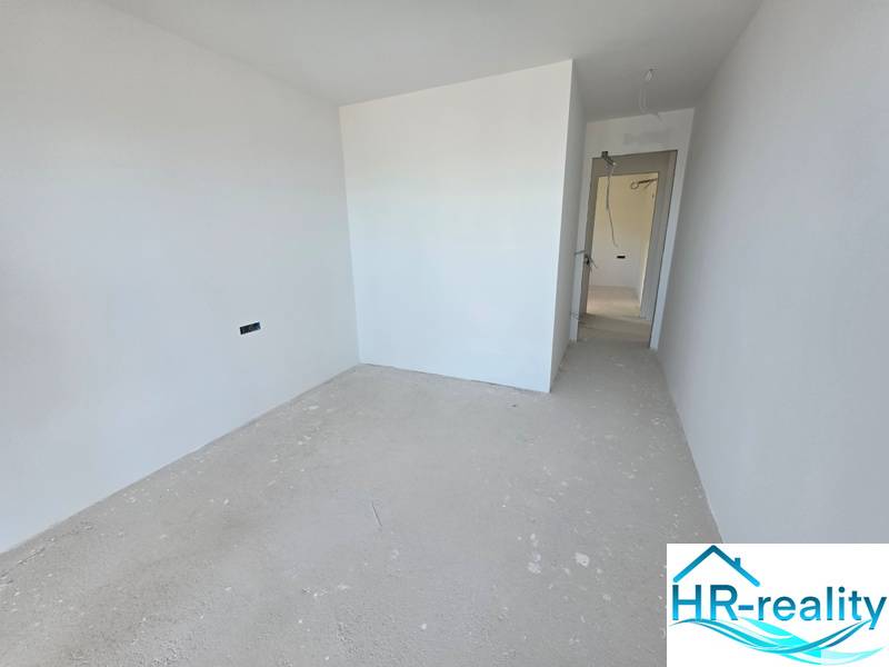 Ferienwohnung mit weißen Wänden und einem einfachen Boden ohne Dekoration.