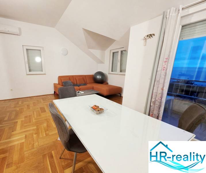 Esszimmer und Wohnzimmer in einem Ferienapartment mit Holzboden.