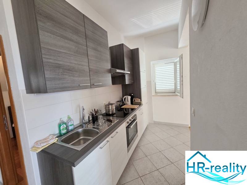 Küche der Ferienwohnung mit moderner Ausstattung und einem Fenster, das den Raum beleuchtet.