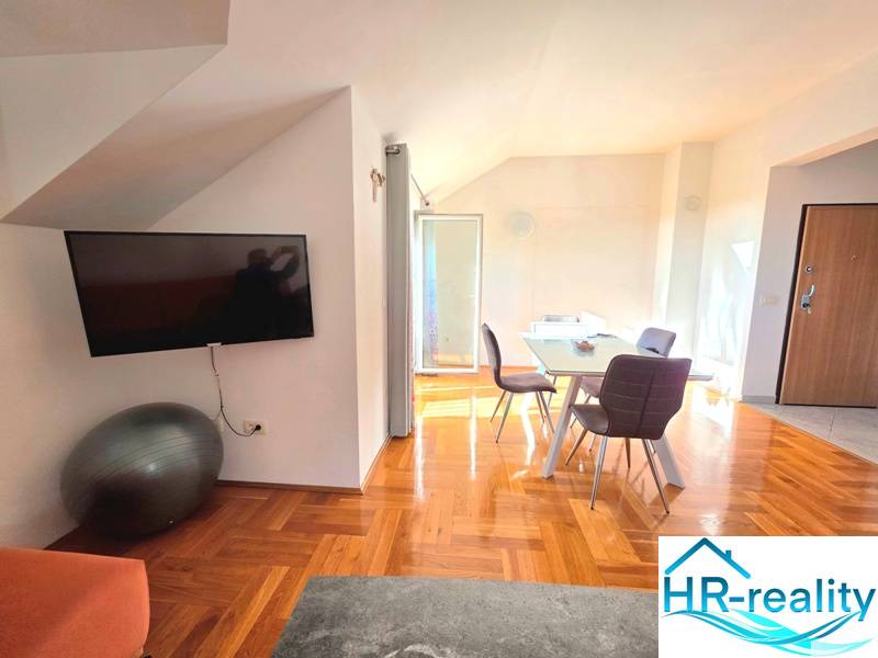 Innenraum einer Ferienwohnung mit Holzboden und Esstisch.