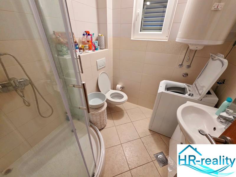 Badezimmer in der Ferienwohnung mit Toilette, Dusche und Waschmaschine.