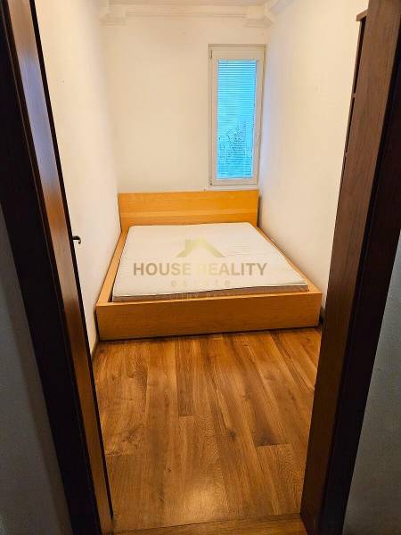 Schlafzimmer in einer 3-Zimmer-Wohnung mit einem Bett und einem Boden in Holzoptik.