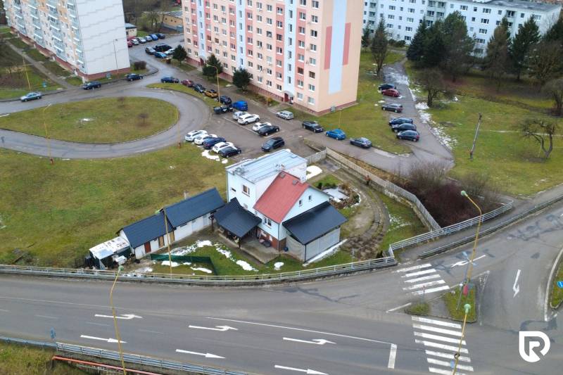 Einfamilienhaus in der SNP-Straße in Považská Bystrica, umgeben von Plattenbauten und einem Parkplatz.