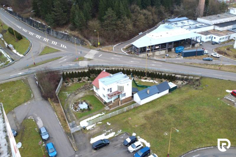 Das Einfamilienhaus in der SNP-Straße in Považská Bystrica, umgeben von Grünflächen und einer Kreuzung.
