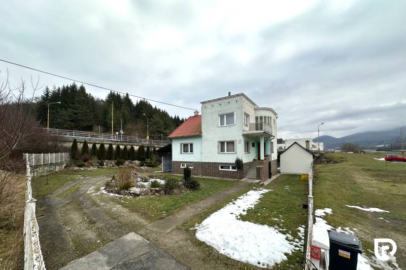 Ein Einfamilienhaus in der SNP-Straße in Považská Bystrica, umgeben von einem verschneiten Garten und einer Zufahrtsstraße.