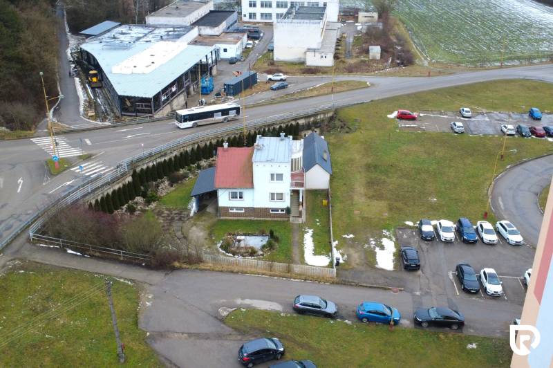 Ein Einfamilienhaus in der SNP-Straße in Považská Bystrica, umgeben von Autos und Grünflächen.