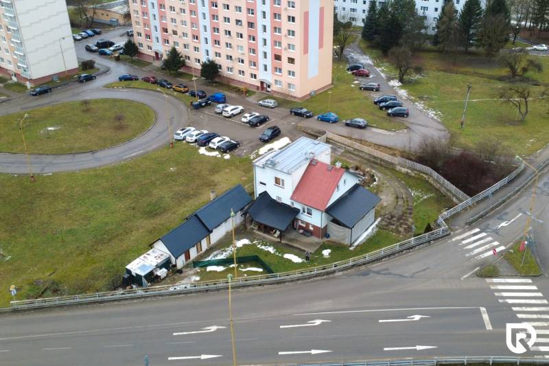 Ein Einfamilienhaus in Považská Bystrica in der Straße SNP, umgeben von einem Parkplatz und Wohnblöcken.