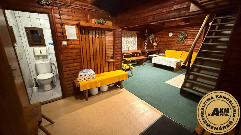 Interieur einer Hütte mit Holzwänden und Einrichtung, bequeme Sitzgelegenheiten, Toilette.