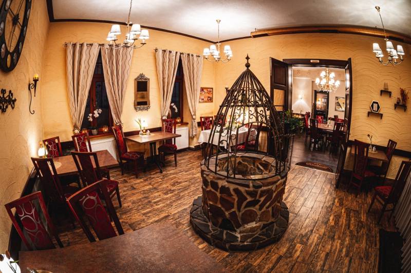 Hotelrestaurant und Pension mit Kamin und Boden in Holzoptik.