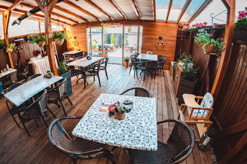 In Hotels und Pensionen mit Holzboden-Dekor gibt es Tische, Stühle und Blumen.