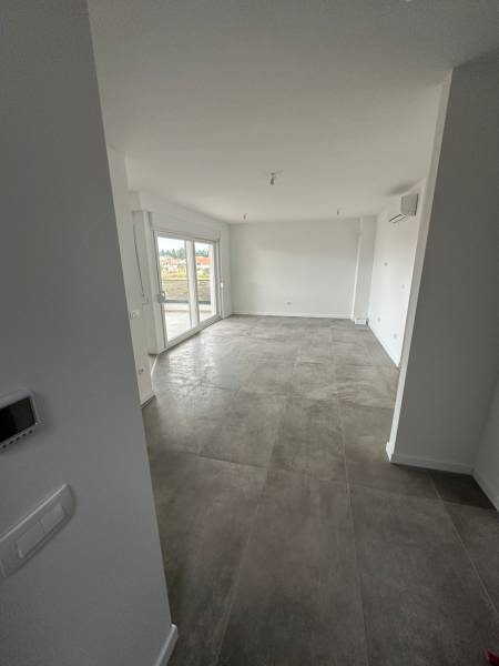 Wohnzimmer in einer 3-Zimmer-Wohnung mit Terrasse und grauen Fliesen.