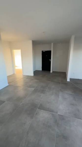 Innenraum einer 3-Zimmer-Wohnung mit großen Fliesen und weißen Wänden.