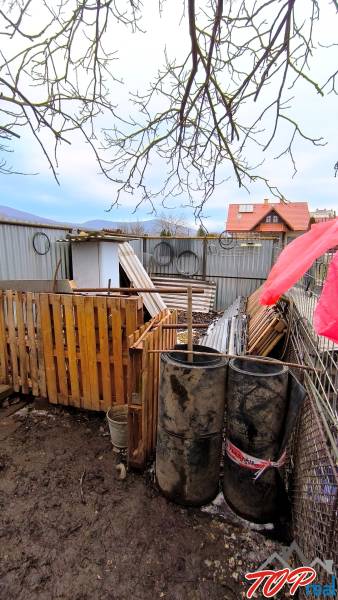 Grundstücke - Wohnen in der Mierová-Straße in Krásnohorské Podhradie mit Materialien und Fässern.